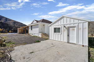 View of front of house featuring board and batten siding, a mountain view, and an outdoor structure