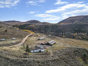 Aerial view of property and surrounding area featuring a mountainous background