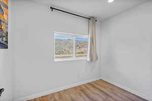 Unfurnished room featuring wood finished floors, recessed lighting, and a mountain view