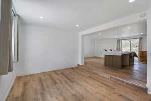 Kitchen featuring recessed lighting, open floor plan, light countertops, light wood-type flooring, and a kitchen island