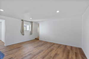 Empty room with light wood-style floors and recessed lighting