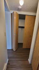 Hallway with dark wood finished floors and a textured ceiling