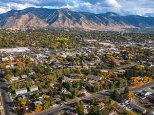 Aerial view of property and surrounding area with a mountainous background and a tree filled landscape