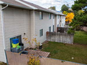 Back of property with roof with shingles and a wooden deck