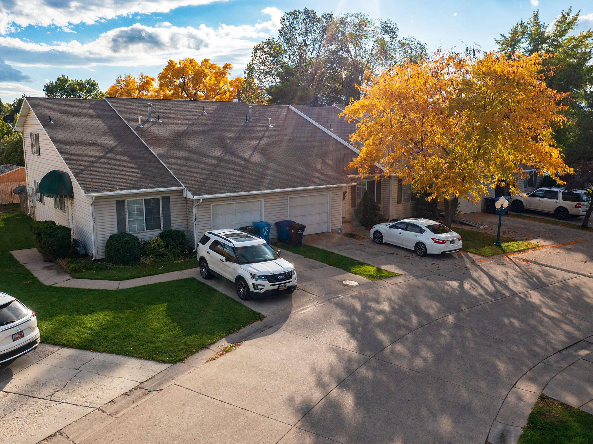 View of front facade with driveway, a front yard, roof with shingles, and an attached garage