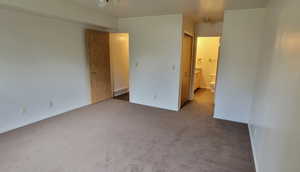 Unfurnished bedroom with carpet flooring, a closet, and connected bathroom