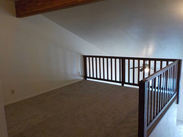 Stairway with carpet floors and a ceiling fan