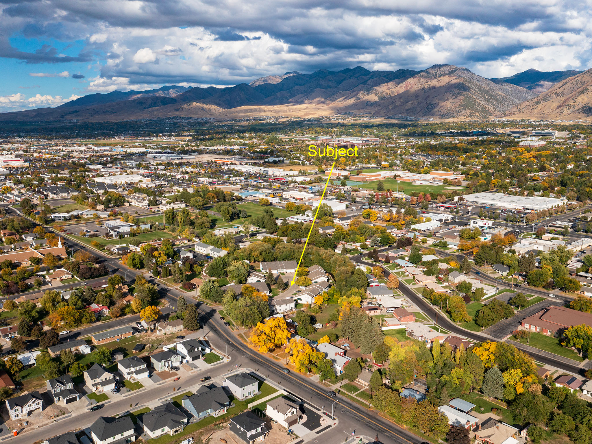 Aerial view of property's location with a mountainous background and nearby suburban area