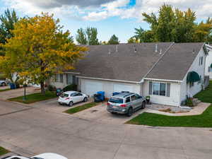 View of front of house with driveway, roof with shingles, and a front lawn