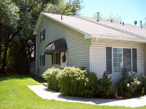 View of side of home with a yard