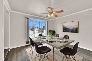 Dining room featuring ornamental molding, dark wood finished floors, and a ceiling fan