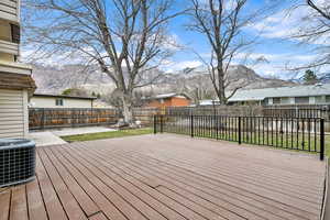 Wooden deck with a fenced backyard, a mountain view, and a residential view