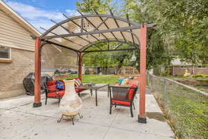Fenced backyard featuring a grill, a patio, an outdoor hangout area, and a pergola