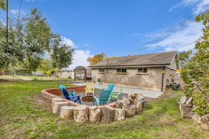 Back of house featuring a patio, an outdoor fire pit, brick siding, and a shingled roof