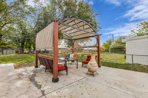 Fenced backyard with a patio area, a pergola, and outdoor dining area