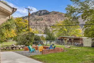 Fenced backyard with a fire pit, a mountain view, and a patio area