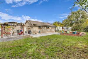 Back of house with brick siding, a patio, a gazebo, roof with shingles, and an outdoor living space