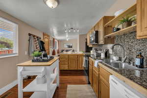 Kitchen featuring decorative backsplash, open shelves, white dishwasher, range with electric stovetop, and dark wood-style floors