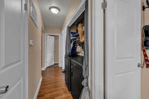 Corridor with dark wood-style floors and washing machine and clothes dryer