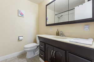 Full bath featuring vanity, light tile patterned floors, and a shower