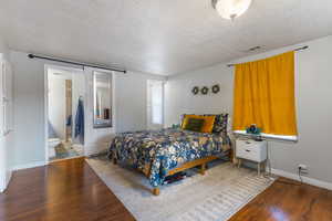 Bedroom featuring a textured ceiling and wood finished floors