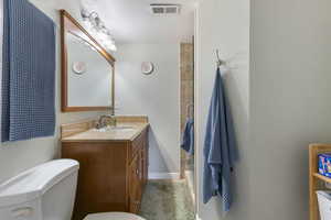 Full bath with vanity, a textured wall, and a shower stall