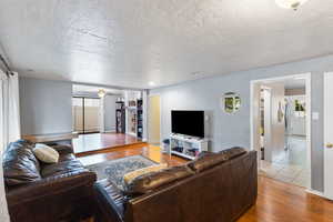 Living area with wood finished floors and a textured ceiling