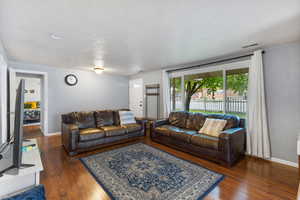 Living area with dark wood-type flooring and a textured ceiling