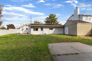 Rear view of property featuring solar panels, a fenced backyard, and stucco siding