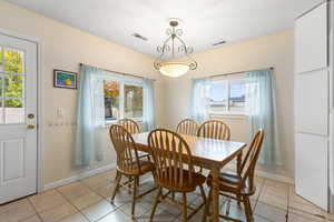 Dining room with light tile patterned flooring and baseboards