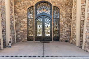 View of exterior entry with stone siding and french doors