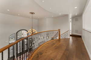 Hallway featuring an upstairs landing, wood-type flooring, recessed lighting, and a chandelier