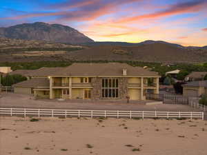 View of front facade with a fenced backyard, a mountain view, and stucco siding