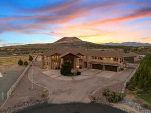 View of front of property featuring curved driveway, a mountain view, and a garage