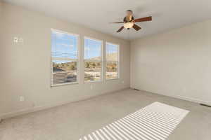 Unfurnished room featuring light colored carpet and ceiling fan
