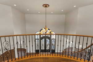Staircase featuring recessed lighting, a chandelier, and wood finished floors