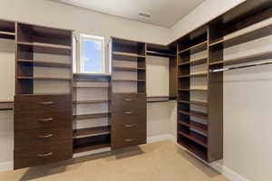 Primary closet with light colored carpet