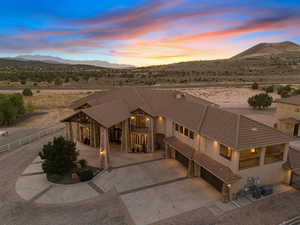 View of front of home featuring driveway, stucco siding, a mountain view, stone siding, and a garage