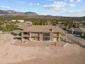 View of front of house with a mountain view, stucco siding, a residential view, and a patio area