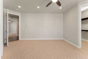 Unfurnished bedroom with recessed lighting, light colored carpet, a spacious closet, and ceiling fan