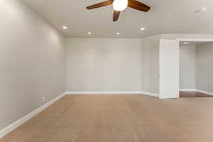 Unfurnished primary suite with recessed lighting, light carpet, ceiling fan, and a smoke detector