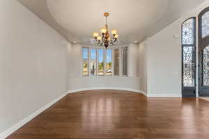 Unfurnished dining area featuring hardwood / wood-style floors, a chandelier, recessed lighting, and a textured ceiling