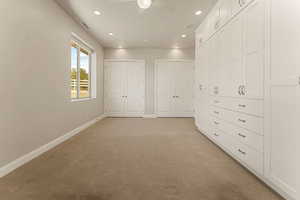 Unfurnished bedroom with multiple closets, light carpet, recessed lighting, a ceiling fan, and a textured ceiling