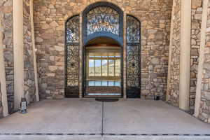 Entrance to property with stone siding and Iron front door