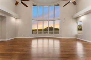 Spare room featuring ceiling fan, dark wood finished floors, a high ceiling, and recessed lighting