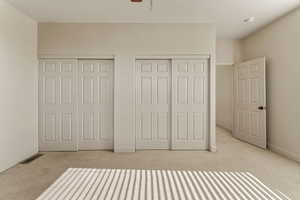 Unfurnished bedroom featuring two closets and carpet flooring