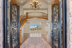 Foyer featuring arched walkways, a chandelier, wood finished floors, elevator, and recessed lighting