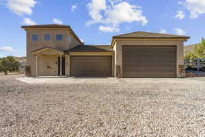 Detached Garage and ADU View of front facade featuring a tile roof, stucco siding, and gravel driveway