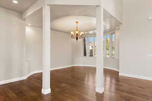 Unfurnished dining area with a chandelier, recessed lighting, and dark wood-style floors