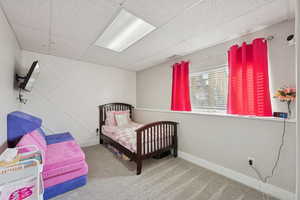 Bedroom featuring carpet flooring and a paneled ceiling